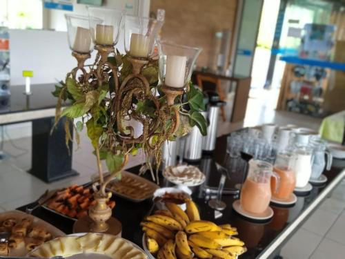 a table with a bunch of bananas and candles at Refúgio Escarpas do Lago in Capitólio