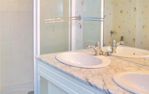 a bathroom with two sinks and a mirror at Awesome Home In Brhand With 2 Bedrooms And Wifi in Moncontour