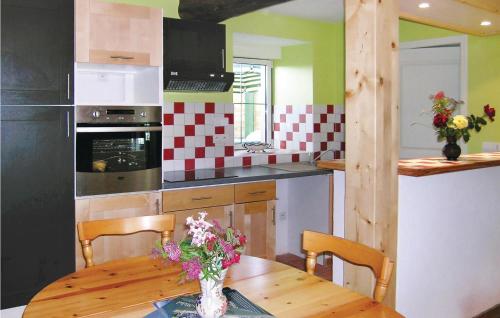 a kitchen with a wooden table with a vase of flowers at Stunning Home In Bréhand With Wifi in Moncontour