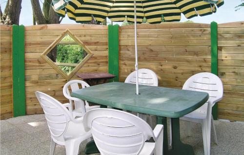 a table and chairs with a green table and an umbrella at Stunning Home In Bréhand With Wifi in Moncontour