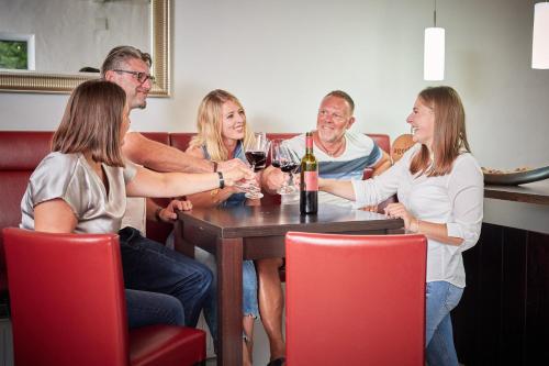a group of people sitting around a table with wine glasses at Winzerhof Agerlhof in Jois