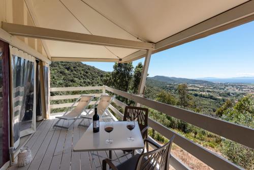 a table and chairs on a deck with a view at Be Vedetta - Relais & Glamping - Adult Only in Scarlino