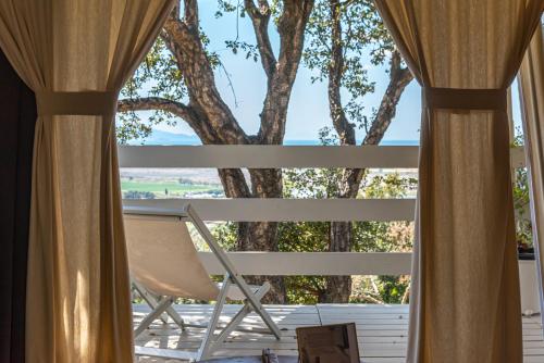 a room with a chair and a window at Be Vedetta - Relais & Glamping - Adult Only in Scarlino