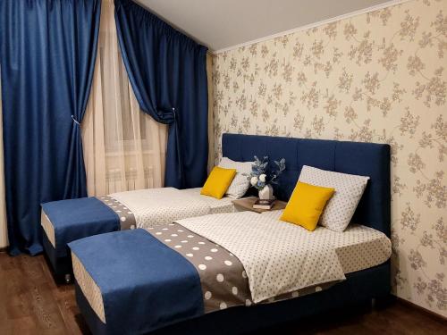 コストロマにあるТаунхаус "БИЗНЕС"のベッドルーム(青いカーテン、黄色の枕付)のベッド2台