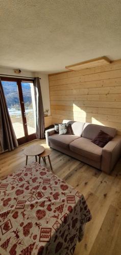 a living room with a couch and a table at studio de charme au Melezet, les Orres. Plein Sud. in Les Orres