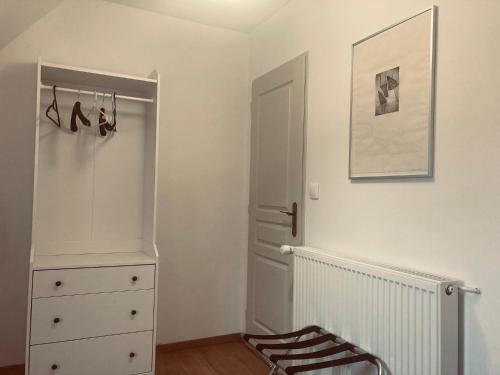 a bedroom with a dresser and a closet with shoes at Le patio de Xénia in La Charité-sur-Loire