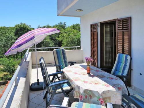 een tafel en stoelen op een balkon met een parasol bij Holiday Home Vista by Interhome in Labin