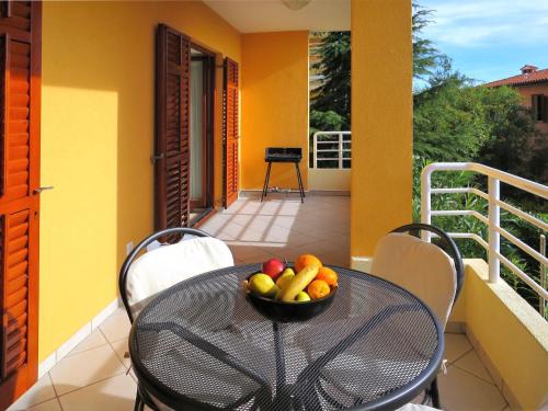a bowl of fruit sitting on a table on a balcony at Apartment Danica by Interhome in Rabac