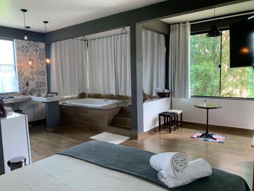 a bathroom with a tub and a bed and a bath room at Solar das Aroeiras in Serra do Cipo