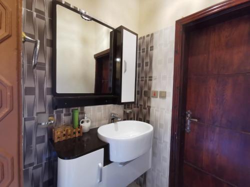 a bathroom with a sink and a mirror at فيلا الوريك Villa Al Warik in Umm Lujj