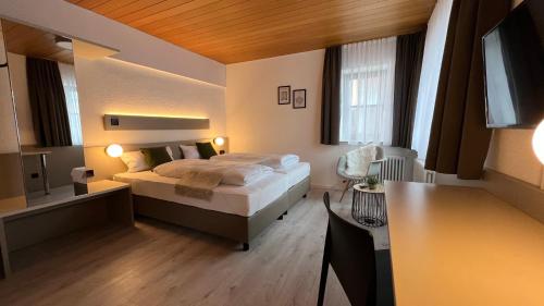 a bedroom with a bed and a desk in it at Hotel Waldhorn in Stuttgart