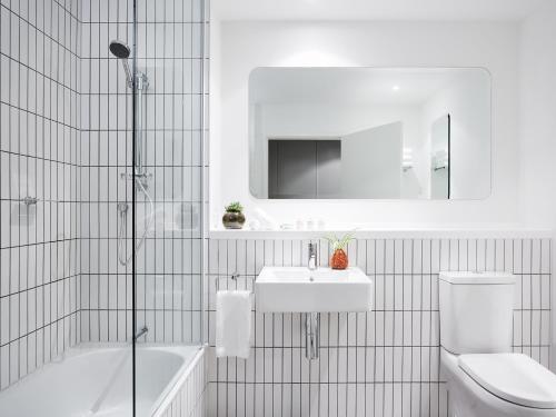 a bathroom with a toilet and a sink and a bath tub at Art Series - The Larwill Studio in Melbourne