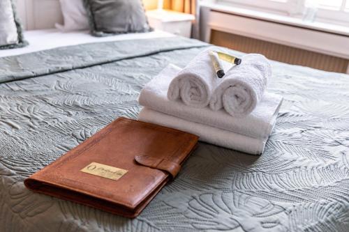 a pair of towels and a wallet on a bed at Hotel Ô Château in Hayange
