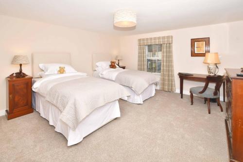 a bedroom with two beds and a table and a desk at The Royal Oak in Biddulph