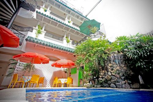 a swimming pool with chairs and umbrellas next to a building at Hotel Galleria in Davao City
