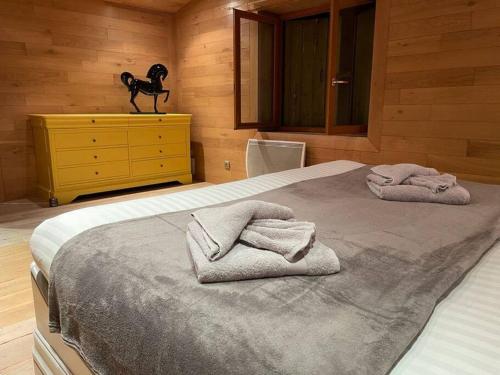 a bedroom with a bed with towels on it at Habitation en bois authentique in Venizy