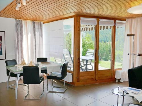 ein Esszimmer mit einem Tisch und Stühlen sowie eine Terrasse in der Unterkunft Apartment Chesa Piz Cotschen 2 by Interhome in Pontresina