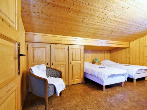 a room with two beds and two chairs in a cabin at Chalet Pierre Blanche by Interhome in Servoz