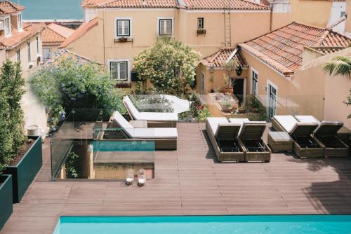an outdoor patio with lounge chairs and a swimming pool at Palacio Ramalhete in Lisbon