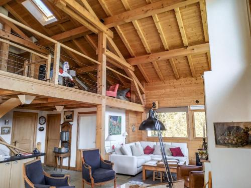 un soggiorno con soffitti in legno e soppalco di Chalet L'Epachat by Interhome a Mémontel