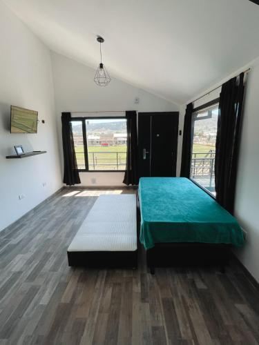 een slaapkamer met een bed en een groot raam bij Bella Vista 2! in Esquel