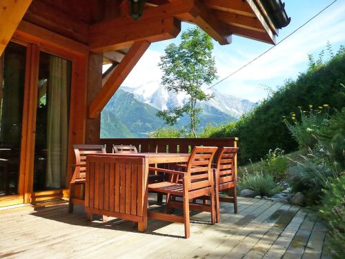 une table et des chaises en bois sur une terrasse avec des montagnes dans l'établissement Chalet du Bulle by Interhome, à Saint-Gervais-les-Bains