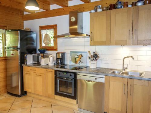 une cuisine avec des placards en bois et des appareils en acier inoxydable dans l'établissement Chalet du Bulle by Interhome, à Saint-Gervais-les-Bains