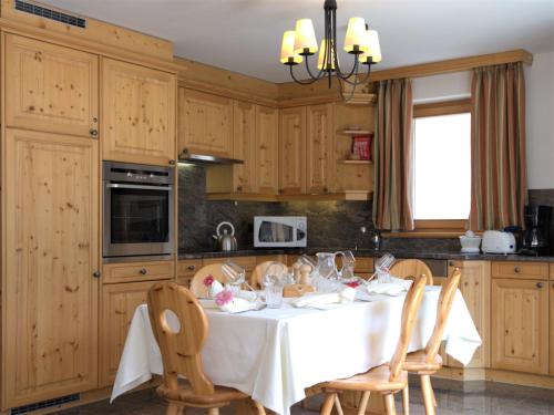 シルヴァプラーナにあるApartment Chesa Dal Luf B5 by Interhomeのキッチン(白いテーブル、木製キャビネット付)