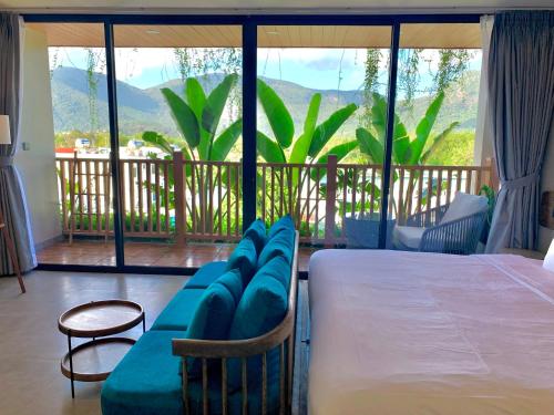 a bedroom with a bed and a balcony with a view at The Mystery Con Dao in Con Dao