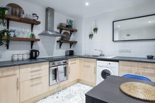 a kitchen with a sink and a washing machine at Ness Central in Inverness