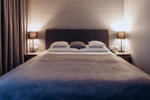 a bedroom with a large bed with two lamps at Miejsca noclegowe i Restauracja Kamiński in Kępno