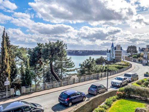 a street with cars parked on a road next to a lake at Apartment Terrasses d'Emeraude-1 by Interhome in Dinard