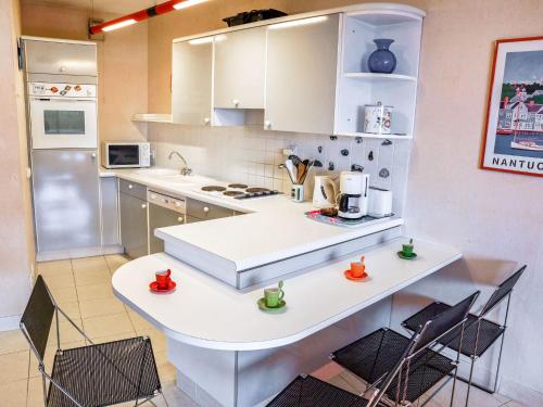 - une cuisine avec un comptoir blanc et des chaises dans l'établissement Apartment Terrasses d'Emeraude-1 by Interhome, à Dinard