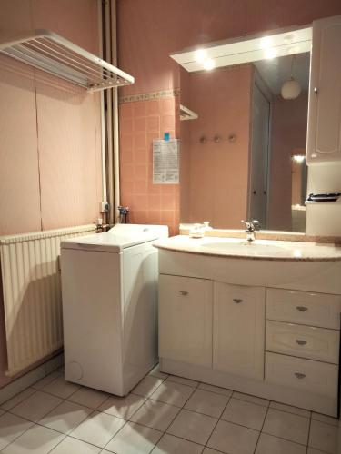 une salle de bain avec un lavabo et un miroir dans l'établissement couchers de soleil en normandie, à Trouville-sur-Mer