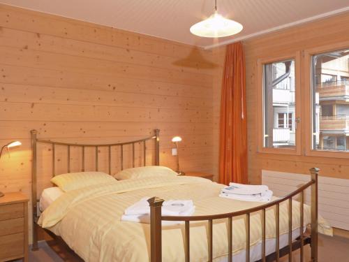 ヴェンゲンにあるApartment Bella Vista-4 by Interhomeの木製の壁のベッドルーム1室(ベッド1台付)