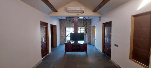 a living room with a tv and a hallway at Vikrama Heritage Resort Pavagadh in Hālol