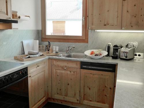 una cocina con armarios de madera y fregadero en Apartment Chesa Vadret 12 by Interhome en Pontresina