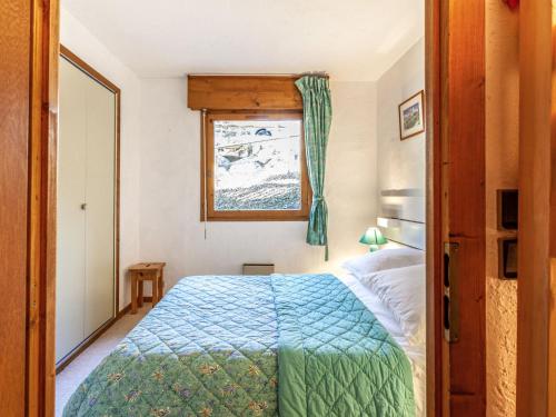 une chambre avec un lit avec une couette bleue et une fenêtre dans l'établissement Apartment Les Grets-9 by Interhome, à Saint-Gervais-les-Bains