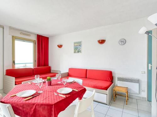 un salon avec une table et un canapé rouge dans l'établissement Apartment L'Open-11 by Interhome, à Fréjus