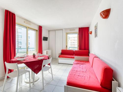 een woonkamer met een rode bank en een tafel bij Apartment L'Open-11 by Interhome in Fréjus