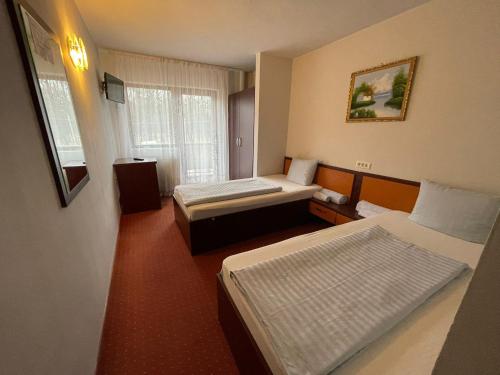 En eller flere senge i et værelse på Hotel Le Baron
