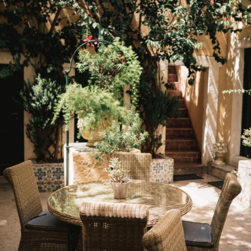 a table and chairs in a courtyard with plants at Palacio Ramalhete in Lisbon
