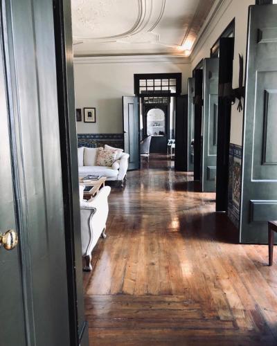 a living room with a white couch and wooden floors at Palacio Ramalhete in Lisbon