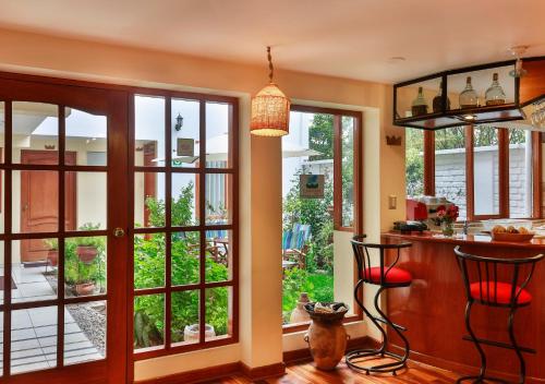 a kitchen with large glass doors and a bar at Laramani Hotel Boutique in Cusco