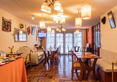 a living room with a table and chairs and a dining room at Laramani Hotel Boutique in Cusco