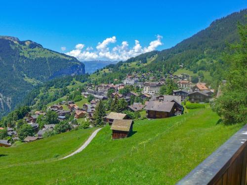 a village on a green hill with a road at Apartment Tschingelhorn Apt- R by Interhome in Wengen