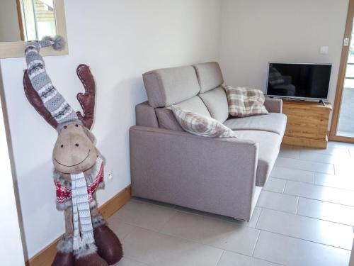 un reno de peluche en una sala de estar con sofá en Apartment Le Clos de la Fontaine-1 by Interhome en Saint-Gervais-les-Bains