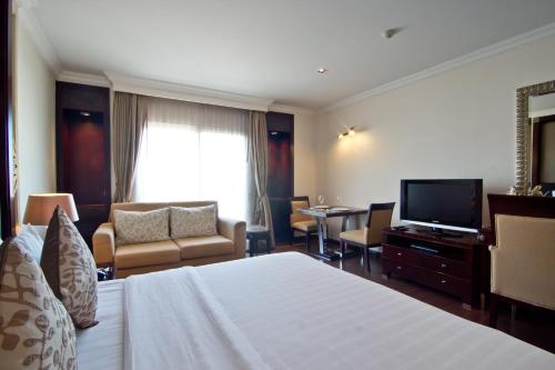 a hotel room with a bed and a television at LK Residence in Pattaya Central