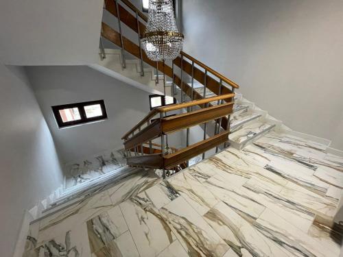 a staircase with a marble floor and a chandelier at Hotel Le Baron in Timişoara