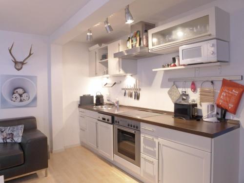 eine Küche mit weißen Schränken und einer Arbeitsplatte in der Unterkunft Apartment Bristol-2 by Interhome in Wengen